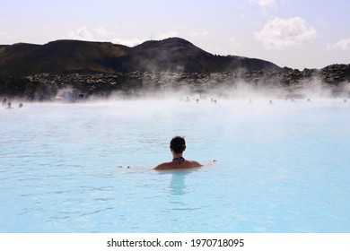 Woman relaxing in the Blue Lagoon, a geothermal spa in Iceland, enjoying bathing in the blue water rich with minerals, algae and silica, famous for its healing properties. - Shutterstock ID 1970718095