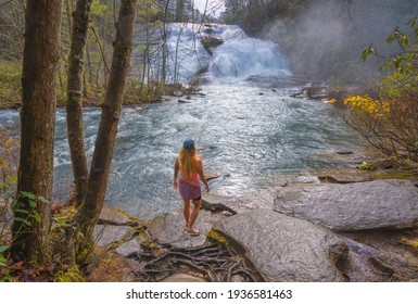 Woman Relaxing By Beautiful Waterfall.  High Falls  Of Dupont State Forest In Brevard. Blue Ridge Mountains, Near Asheville, Western North Carolina, USA.