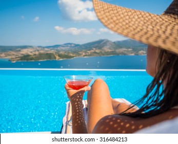 Woman Relaxing By The Infinity Pool In Greece