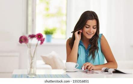 Woman Relaxing With Cup Of Coffee And Magazine 