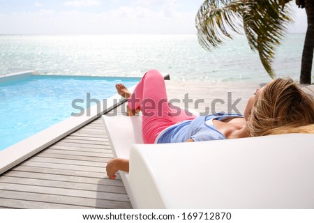 Woman relaxing in deck chair in front of the sea