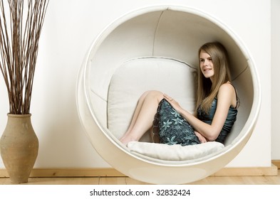 Woman Relaxing In An Egg Chair