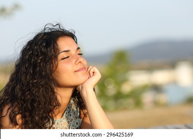 Woman relaxing and enjoying the sun in a warmth park at sunset - Shutterstock ID 296425169