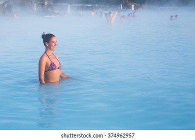 Woman relaxing in geothermal spa in hot spring pool in Iceland. Girl enjoying bathing in a blue water lagoon. - Shutterstock ID 374962957