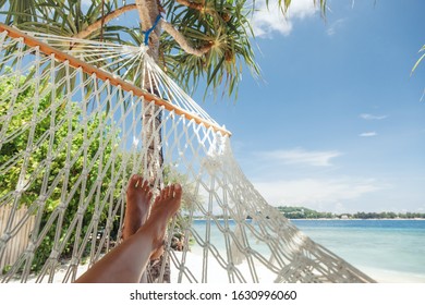 Woman Relaxing In The Hammock On Tropical Beach, Hot Sunny Day, Pov View Of Feet