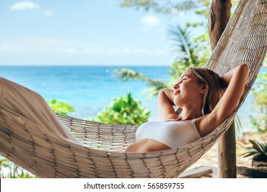 Woman relaxing in the hammock on tropical beach, hot sunny day - Powered by Shutterstock