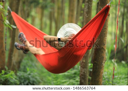Woman relaxing in hammock in tropical rainforest
