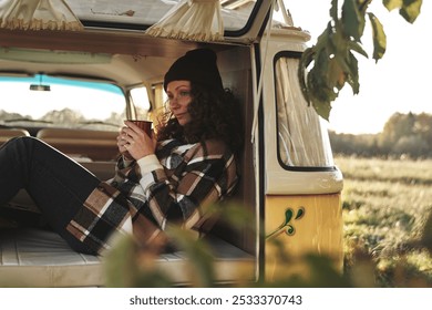 Woman Relaxing Inside Camper Van with a Hot Drink - Powered by Shutterstock