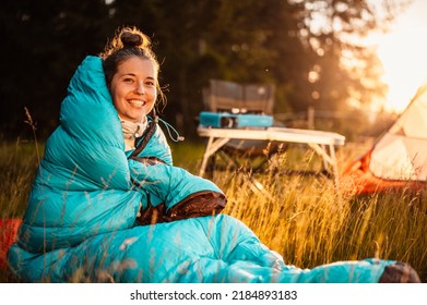 Woman relaxing and lie in a sleeping bag in the tent. Sunset camping in forest. Mountains landscape travel lifestyle camping. Summer travel outdoor adventure - Shutterstock ID 2184893183