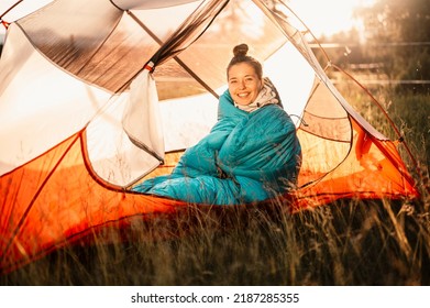 Woman relaxing and lie in a sleeping bag in the tent. Sunset camping in forest. Mountains landscape travel lifestyle camping. Summer travel outdoor adventure - Powered by Shutterstock