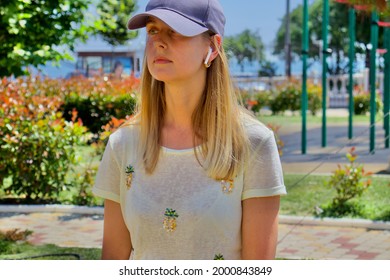 Woman relaxing and listening music by headphones in the park in sunny day - Powered by Shutterstock