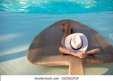 Woman Relaxing At The Luxury Poolside. Girl At Travel Spa Resort Pool. Summer Luxury Vacation. 