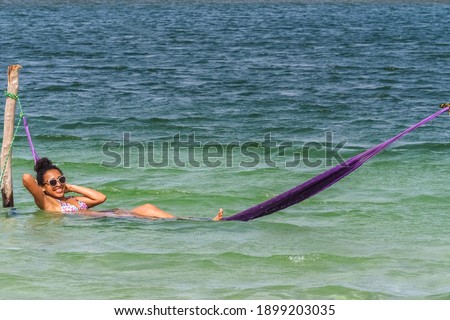 Woman relaxing lying in a hammock inside the lake in Boa Vista, Roraima, northern Brazil.
In hammock on Water.