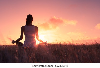 Woman Relaxing Meditating In Grass Field.  