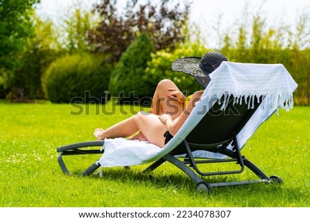 Woman relaxing on beach sitting on sunbed 