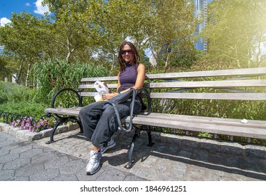 Woman Relaxing On A Bench Along Hudson River, Manhattan, USA.