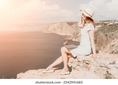 Woman Relaxing on a Cliffside with a Laptop - Powered by Shutterstock