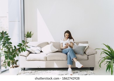 Woman relaxing on comfortable couch. Satisfied girl sitting on sofa. - Shutterstock ID 1862742928