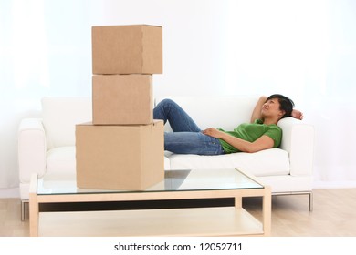 Woman Relaxing On Couch With Boxes In Foreground