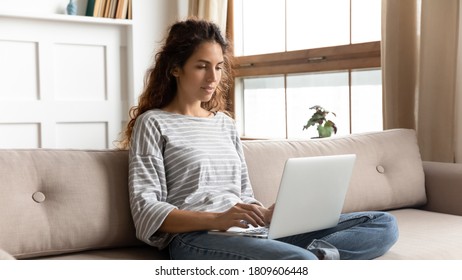 Woman relaxing on couch using laptop search information on internet. Freelance female do remote job, blogger influencer working from home, weekend free time activity in social media networks concept - Shutterstock ID 1809606448