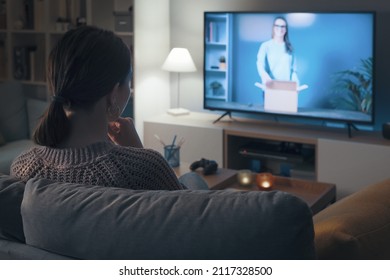 Woman Relaxing On The Couch And Watching An Unboxing Video Online On Her Smart TV