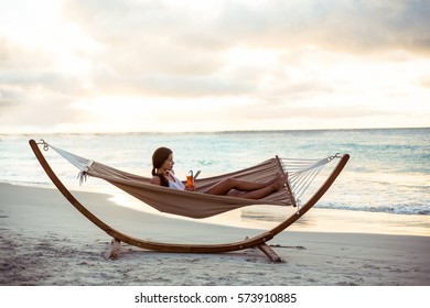 Woman Relaxing On A Hammock On The Beach