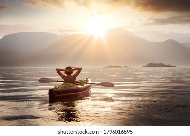 Woman Relaxing On Her Kayak During A Colorful Summer Sunset. Taken In Howe Sound, North Of Vancouver, British Columbia, Canada.