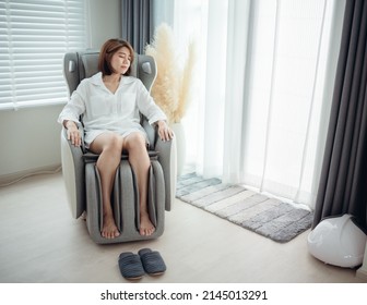 A woman is relaxing on her massage chair in the living room while napping. - Shutterstock ID 2145013291