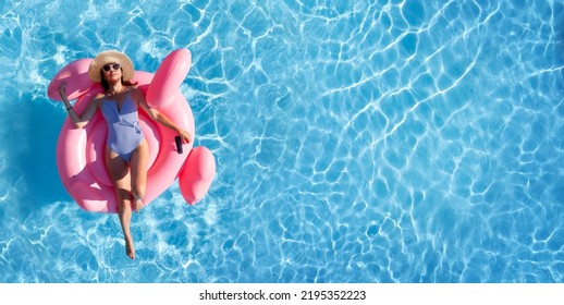 Woman relaxing on pink flamingo inflatable ring. Sunny pool vacation. Flat lay with copy space - Powered by Shutterstock