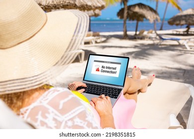 Woman Relaxing On Remote Beach While On Vacation And Using Laptop Computer With An Error Message On The Screen Showing No Internet Connection Available