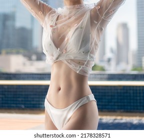 Woman Relaxing On A Rooftop Pool With Beautiful City View Background.