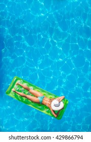 Woman Relaxing In A Pool On A Lilo