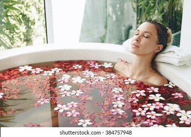 Woman Relaxing In Round Outdoor Bath With Tropical Flowers, Organic Skin Care, Luxury Spa Hotel, Lifestyle Photo