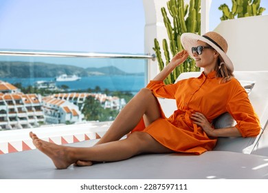 woman relaxing in sunbed at penthouse apartment and enjoying summer vacations in Tenerife
