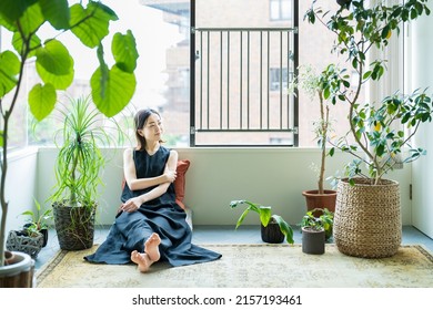 A woman relaxing surrounded by foliage plants in the room