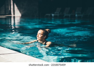 Woman relaxing in the swimming pool. - Shutterstock ID 2210075459