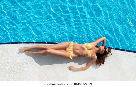 Woman relaxing in swimming pool on summer vacation. Hot sunny holiday concept. Top view flat lay with copy space