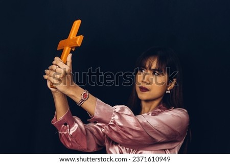 Woman in religion concept. Hands praying to the GOD while holding a crucifix symbol . Woman holding a cross in her hands. Human hands holding a cross holy and prayed for blessings from God.