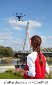 Woman With Remote Control And Flying Surveillance Drone