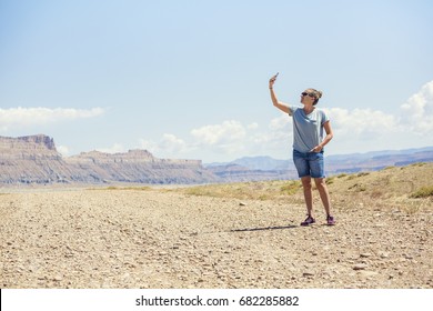 Woman In A Remote Location Holding Up Mobile Phone Trying To Get A Signal