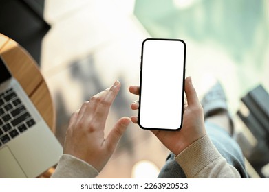 A woman remote working at the cafe, using her smartphone to contact someone, using mobile application, checking mail box on her phone. phone white screen mockup, close-up image - Powered by Shutterstock