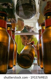 Woman Removing A Cold Beer From The Refrigerator. Creative Photography. Lifestyle