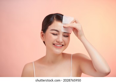  Woman Removing Oil From Face Using Blotting Papers.