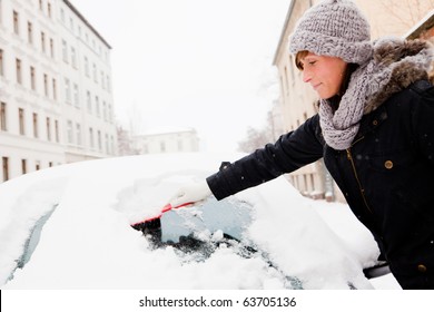 Woman Removing Snow From Car Window