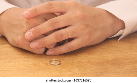 Woman Removing Wedding Ring From Finger