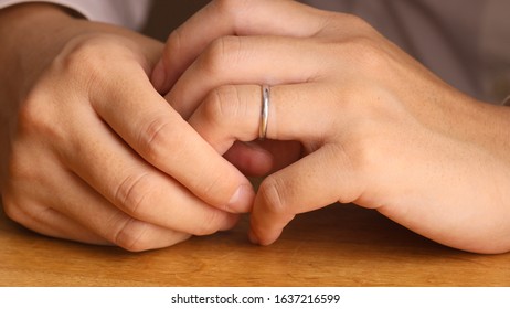 Woman Removing Wedding Ring From Finger