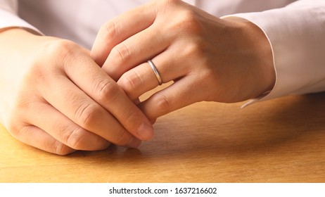 Woman Removing Wedding Ring From Finger