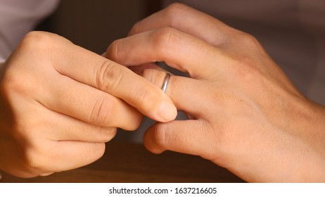 Woman Removing Wedding Ring From Finger