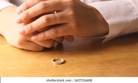 Woman Removing Wedding Ring From Finger