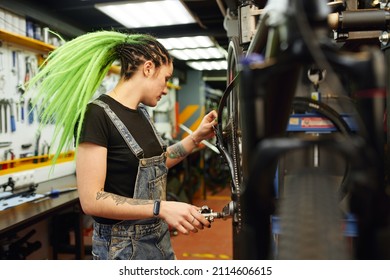 Woman Repairing Bike In Workshop